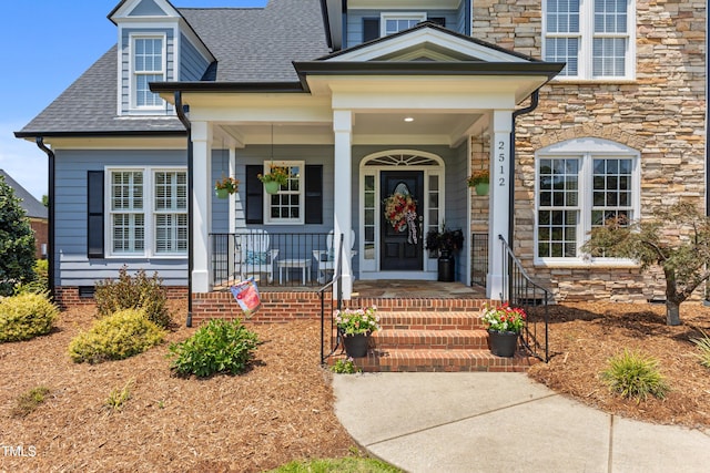 2512 Stewart St, Fuquay Varina, NC 27526 - doorway to property featuring stone siding, roof with shingles, crawl space, and covered porch