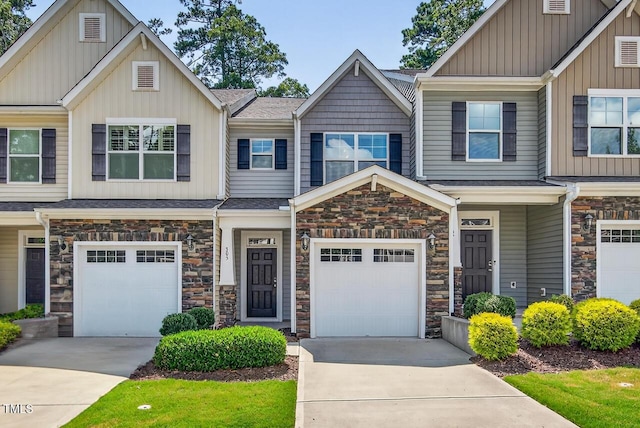 305 Lionel St, Durham, NC 27705 - view of front of house featuring stone siding, driveway, board and batten siding, and a garage