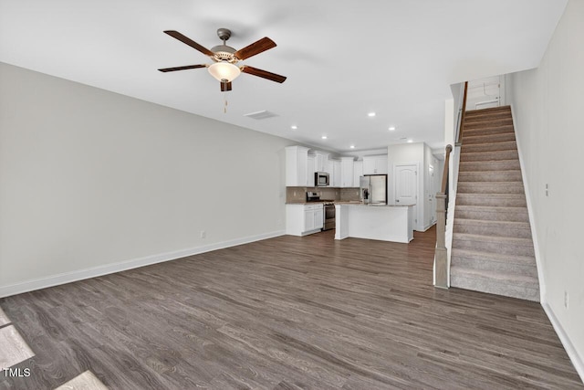 305 Lionel St, Durham, NC 27705 - unfurnished living room with a ceiling fan, dark wood-type flooring, recessed lighting, and stairway
