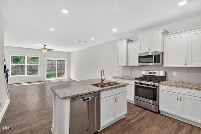 305 Lionel St, Durham, NC 27705 - kitchen featuring appliances with stainless steel finishes, open floor plan, decorative backsplash, white cabinets, and dark wood-style floors
