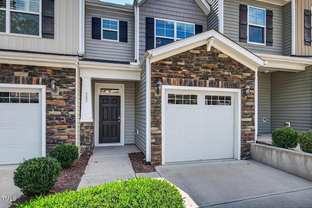 305 Lionel St, Durham, NC 27705 - view of exterior entry featuring stone siding, concrete driveway, and a garage