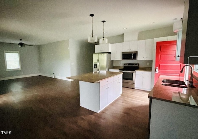 622 Williams St, Enfield, NC 27823 - kitchen with appliances with stainless steel finishes, white cabinets, dark countertops, a ceiling fan, and decorative light fixtures