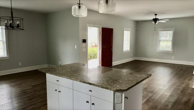 622 Williams St, Enfield, NC 27823 - kitchen with dark wood-type flooring, open floor plan, white cabinets, and a chandelier
