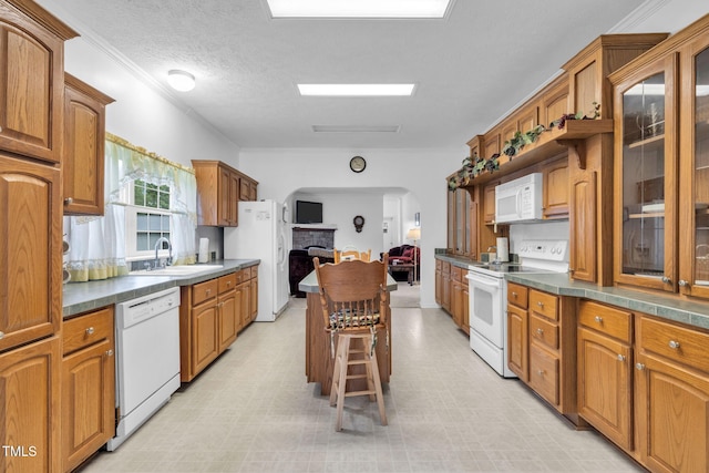 9633 Grassy Creek Rd, Bullock, NC 27507 - kitchen with white appliances, arched walkways, glass insert cabinets, brown cabinetry, and dark countertops