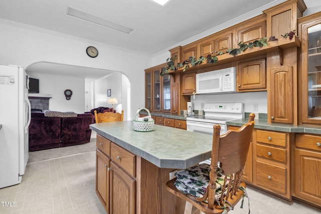 9633 Grassy Creek Rd, Bullock, NC 27507 - kitchen with white appliances, arched walkways, brown cabinets, crown molding, and glass insert cabinets