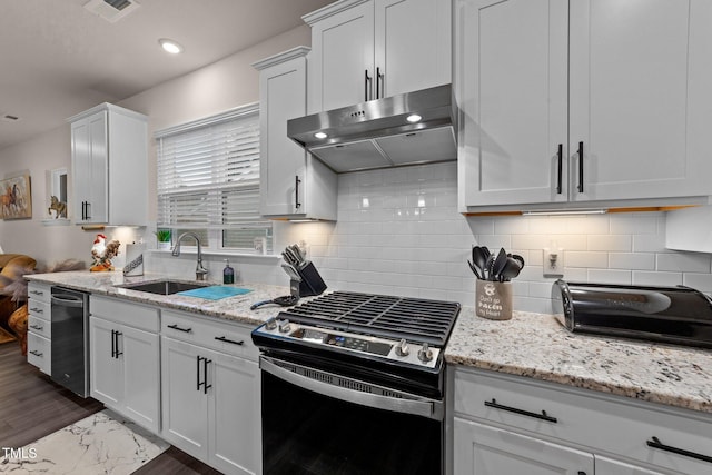 2370 Friars Head Ct, Fuquay Varina, NC 27526 - kitchen with gas range oven, stainless steel dishwasher, under cabinet range hood, white cabinetry, and light stone counters