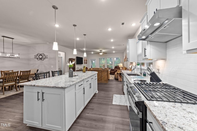 2370 Friars Head Ct, Fuquay Varina, NC 27526 - kitchen featuring stainless steel gas stove, extractor fan, open floor plan, a center island, and tasteful backsplash