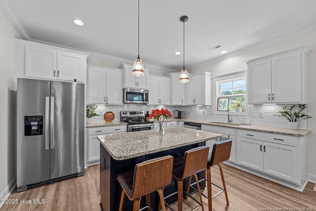 829 Warwick Ln, Carthage, NC 28327 - kitchen featuring stainless steel appliances, light wood finished floors, white cabinetry, tasteful backsplash, and crown molding