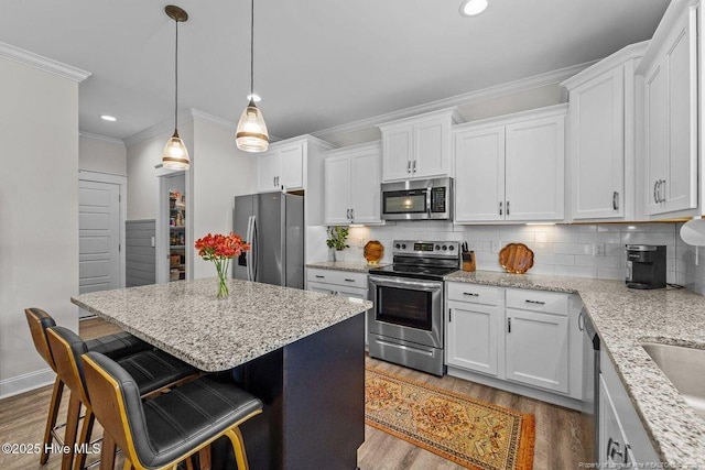 829 Warwick Ln, Carthage, NC 28327 - kitchen featuring stainless steel appliances, crown molding, wood finished floors, white cabinets, and recessed lighting