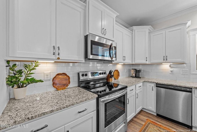 829 Warwick Ln, Carthage, NC 28327 - kitchen featuring stainless steel appliances, white cabinetry, wood finished floors, backsplash, and light stone countertops