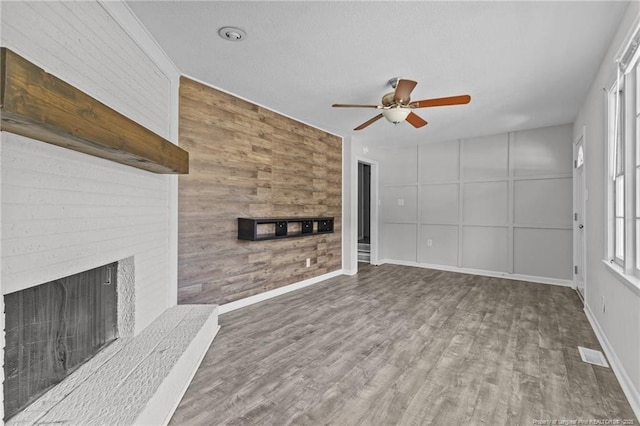 801 Algood Ave, Hope Mills, NC 28348 - unfurnished living room with ceiling fan, wooden walls, a fireplace, and wood finished floors