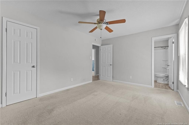 801 Algood Ave, Hope Mills, NC 28348 - unfurnished bedroom featuring light colored carpet, ensuite bathroom, a textured ceiling, and ceiling fan