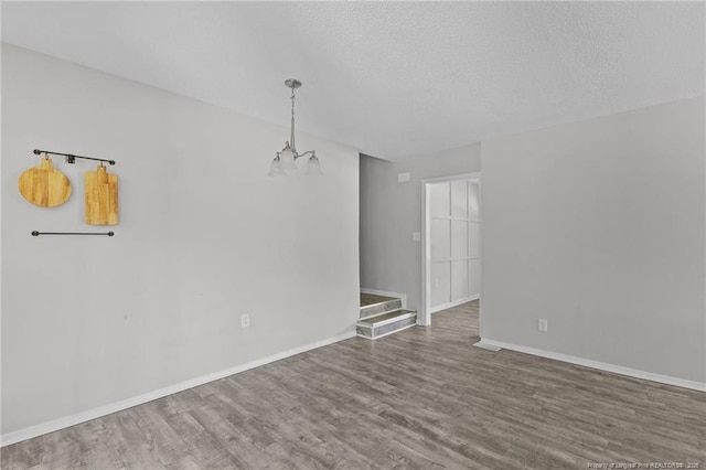 801 Algood Ave, Hope Mills, NC 28348 - empty room with a chandelier, wood finished floors, and a textured ceiling