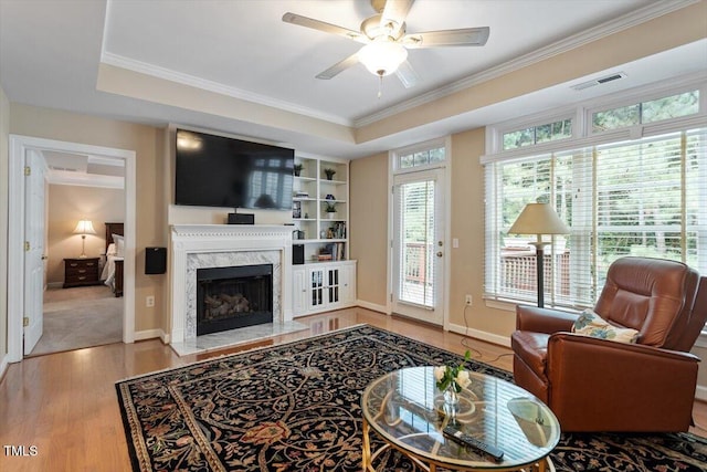 4742 Ludwell Branch Ct, Raleigh, NC 27612 - living room with wood finished floors, crown molding, ceiling fan, a premium fireplace, and a tray ceiling