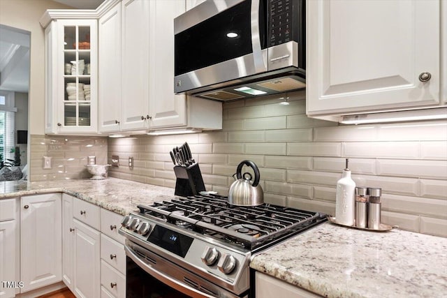 4742 Ludwell Branch Ct, Raleigh, NC 27612 - kitchen featuring stainless steel appliances, white cabinets, glass insert cabinets, and tasteful backsplash