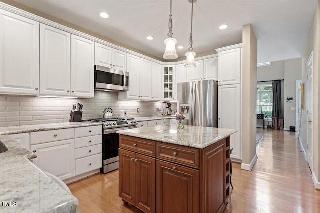 4742 Ludwell Branch Ct, Raleigh, NC 27612 - kitchen featuring stainless steel appliances, white cabinets, decorative backsplash, pendant lighting, and light wood-style flooring