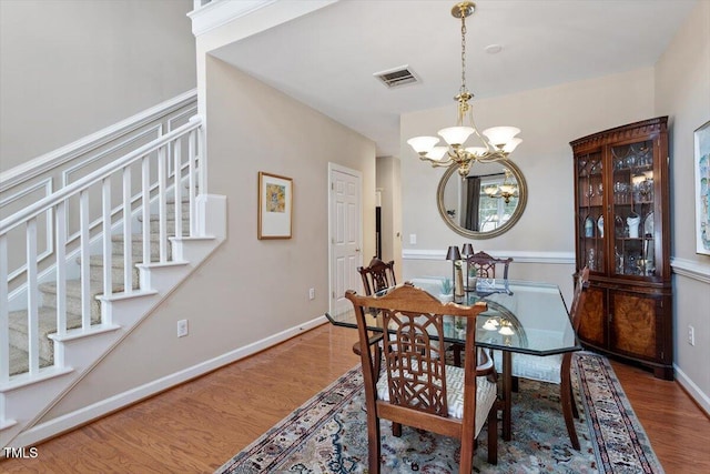 4742 Ludwell Branch Ct, Raleigh, NC 27612 - dining room with wood finished floors, a chandelier, and stairway