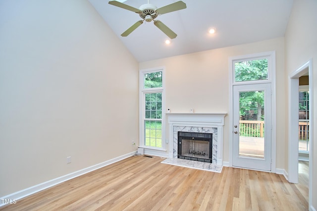 119 Heatherwood Dr, Apex, NC 27502 - unfurnished living room featuring a high end fireplace, healthy amount of natural light, ceiling fan, light wood-style floors, and high vaulted ceiling