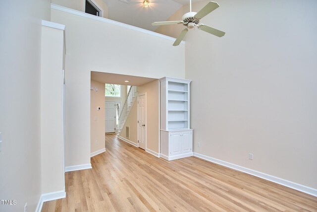 119 Heatherwood Dr, Apex, NC 27502 - unfurnished room featuring stairway, ceiling fan, light wood finished floors, and a towering ceiling