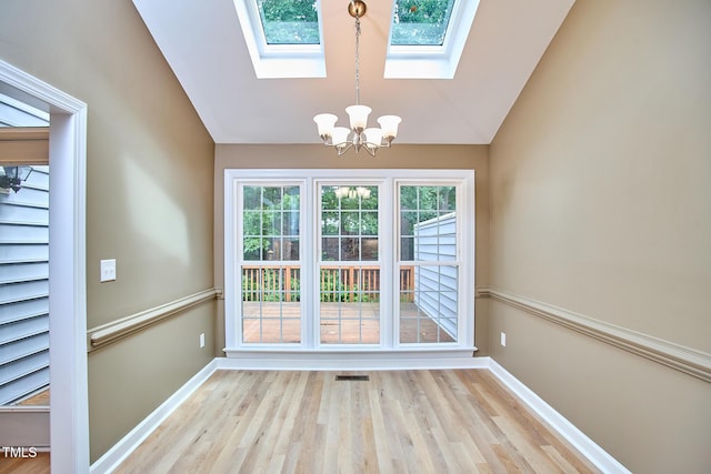 119 Heatherwood Dr, Apex, NC 27502 - doorway featuring a chandelier, lofted ceiling, light wood-style floors, and a skylight