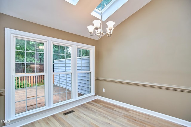 119 Heatherwood Dr, Apex, NC 27502 - spare room with a skylight, a chandelier, light wood-style flooring, and lofted ceiling