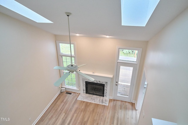 119 Heatherwood Dr, Apex, NC 27502 - unfurnished living room featuring a skylight, wood finished floors, a high end fireplace, and plenty of natural light