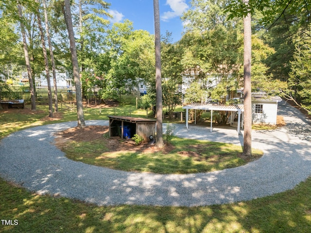 101 Hunter Pl, Carrboro, NC 27510 - view of front of home featuring gravel driveway, a detached carport, an outdoor structure, and view of wooded area