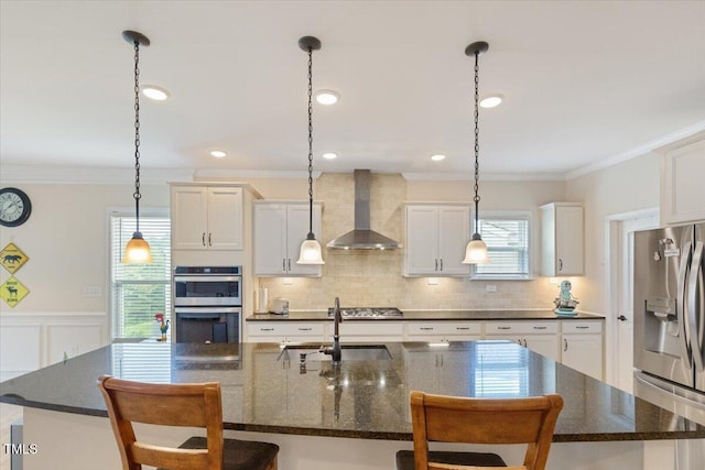 470 Duggins Pt, Apex, NC 27523 - kitchen with stainless steel appliances, wall chimney exhaust hood, a kitchen breakfast bar, healthy amount of natural light, and ornamental molding