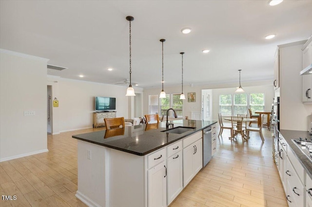 470 Duggins Pt, Apex, NC 27523 - kitchen featuring appliances with stainless steel finishes, a kitchen island with sink, light wood-style floors, crown molding, and decorative light fixtures