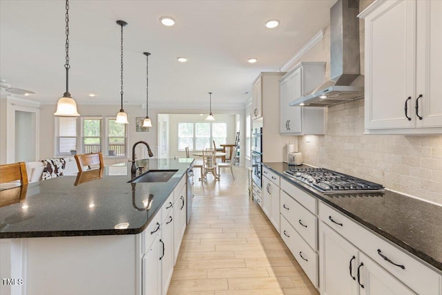 470 Duggins Pt, Apex, NC 27523 - kitchen featuring wall chimney exhaust hood, appliances with stainless steel finishes, ornamental molding, a large island, and tasteful backsplash