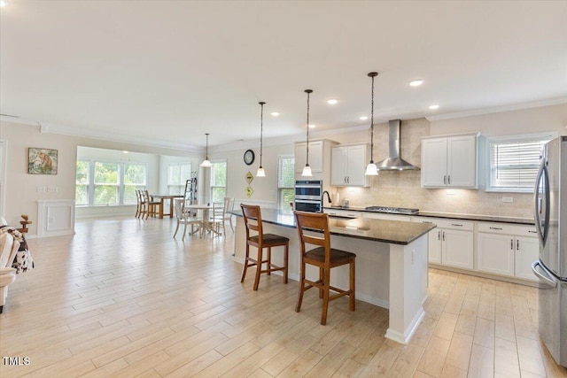 470 Duggins Pt, Apex, NC 27523 - kitchen featuring wall chimney range hood, stainless steel appliances, crown molding, tasteful backsplash, and white cabinetry