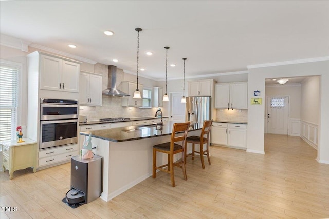 470 Duggins Pt, Apex, NC 27523 - kitchen featuring stainless steel appliances, wall chimney range hood, crown molding, dark countertops, and a breakfast bar area