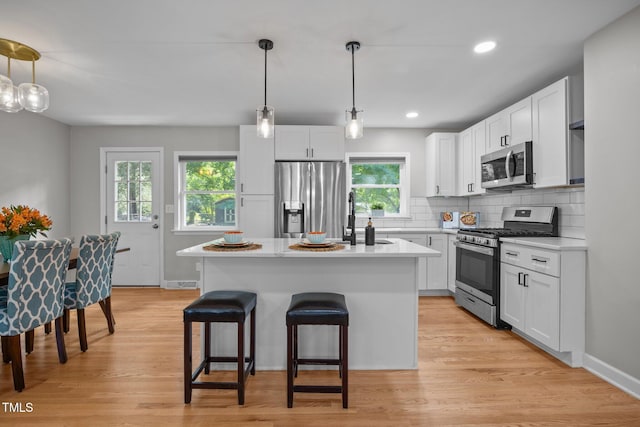 4011 Garrett Rd, Durham, NC 27707 - kitchen featuring appliances with stainless steel finishes, light countertops, a kitchen bar, decorative backsplash, and recessed lighting