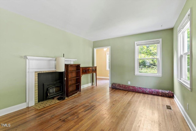 1300 Ruffin St, Durham, NC 27701 - unfurnished living room with wood-type flooring, a wood stove, and plenty of natural light