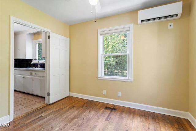 1300 Ruffin St, Durham, NC 27701 - unfurnished dining area featuring a wall mounted air conditioner, light wood-type flooring, and a ceiling fan