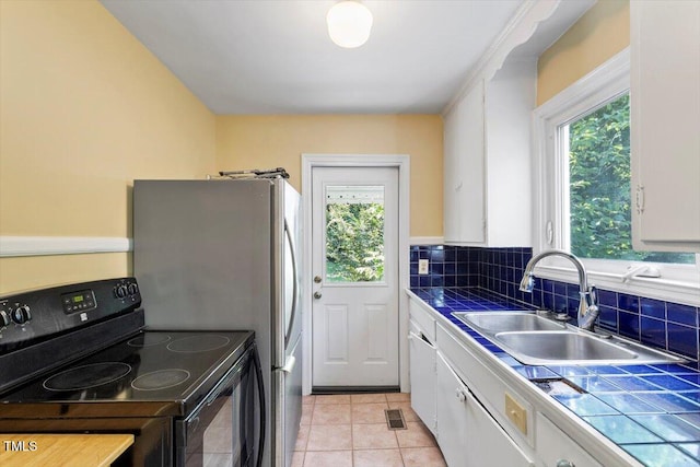 1300 Ruffin St, Durham, NC 27701 - kitchen featuring black electric range oven, tile countertops, white cabinetry, and plenty of natural light