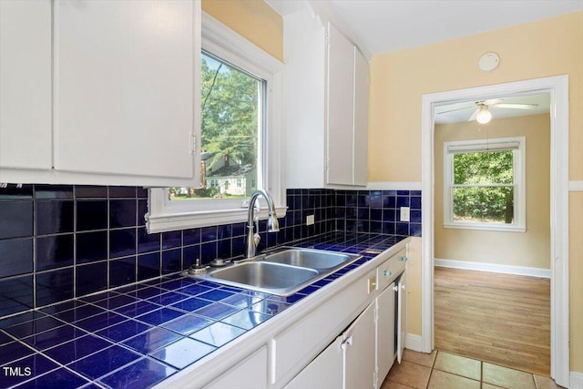 1300 Ruffin St, Durham, NC 27701 - kitchen with tile countertops, white cabinets, decorative backsplash, and plenty of natural light