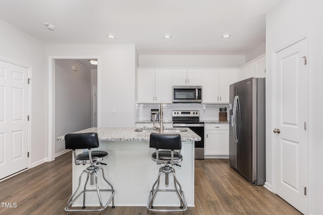 331 Sturgeon St, Smithfield, NC 27577 - kitchen featuring stainless steel appliances, white cabinets, decorative backsplash, a kitchen bar, and a kitchen island with sink