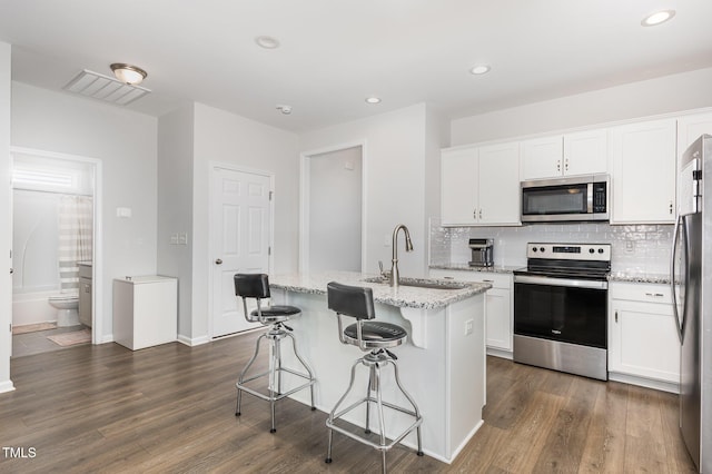 331 Sturgeon St, Smithfield, NC 27577 - kitchen with stainless steel appliances, dark wood-type flooring, backsplash, white cabinets, and recessed lighting
