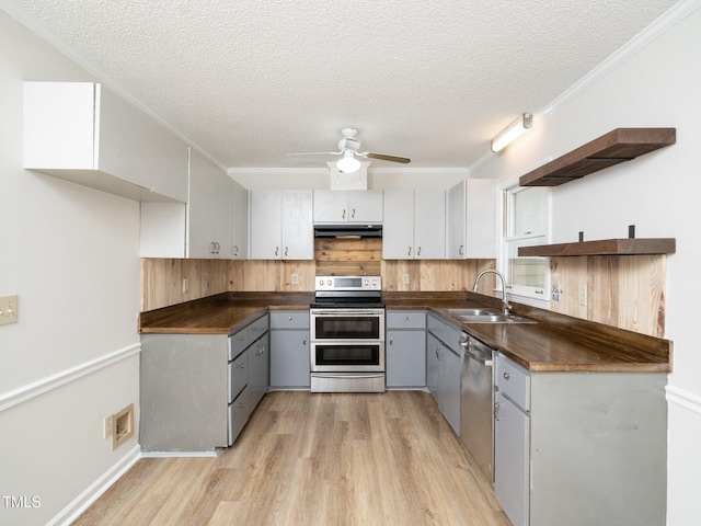 129 Nottingham Ct, Youngsville, NC 27596 - kitchen with appliances with stainless steel finishes, dark countertops, under cabinet range hood, light wood-type flooring, and a textured ceiling