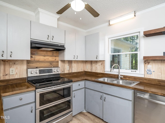 129 Nottingham Ct, Youngsville, NC 27596 - kitchen featuring stainless steel appliances, under cabinet range hood, a textured ceiling, crown molding, and wooden walls
