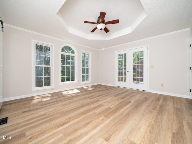129 Nottingham Ct, Youngsville, NC 27596 - spare room with a tray ceiling, a ceiling fan, light wood-style floors, french doors, and crown molding