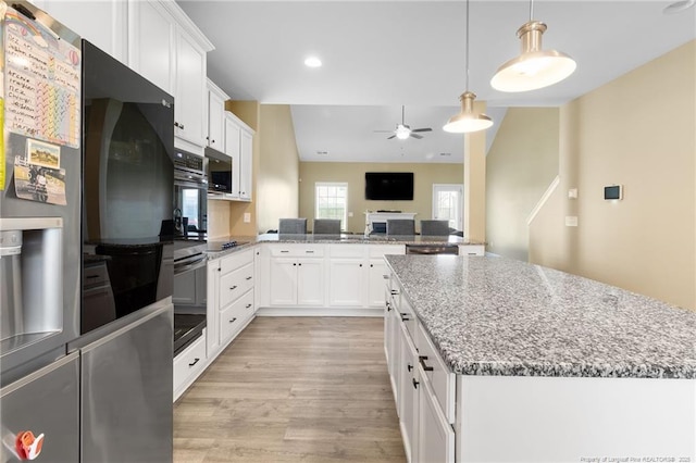 1657 Stackhouse Dr, Fayetteville, NC 28314 - kitchen featuring stainless steel appliances, ceiling fan, light wood-style flooring, white cabinets, and light stone counters