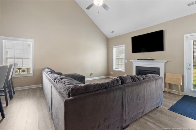 1657 Stackhouse Dr, Fayetteville, NC 28314 - living room with high vaulted ceiling, ceiling fan, light wood-style flooring, a fireplace, and healthy amount of natural light