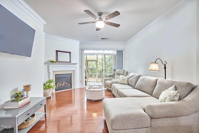 10410 Rosegate Ct Unit 105, Raleigh, NC 27617 - living area with ornamental molding, a ceiling fan, a tile fireplace, and wood finished floors
