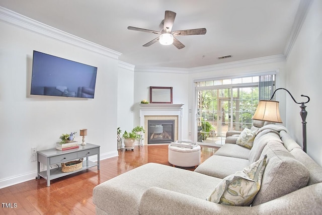 10410 Rosegate Ct Unit 105, Raleigh, NC 27617 - living area featuring ornamental molding, wood finished floors, a ceiling fan, and a tiled fireplace