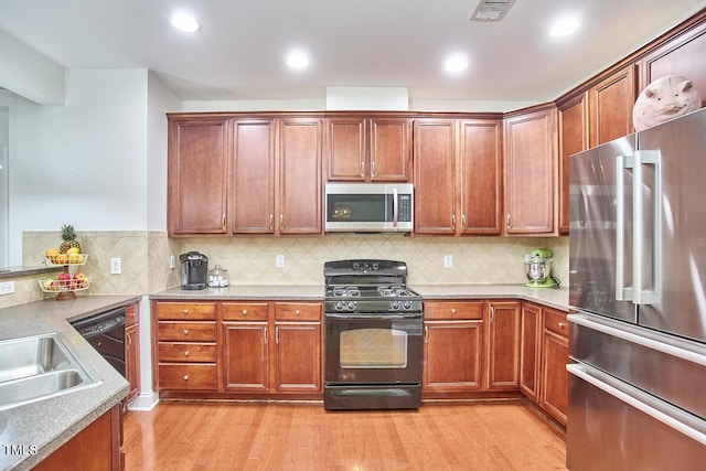 10410 Rosegate Ct Unit 105, Raleigh, NC 27617 - kitchen featuring appliances with stainless steel finishes, light wood finished floors, backsplash, recessed lighting, and light countertops
