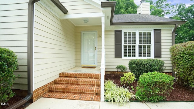 8001 Flanagan Pl, Raleigh, NC 27612 - property entrance featuring a chimney and roof with shingles