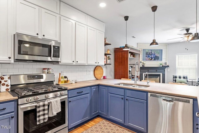 109 Covenant Rock Ln, Holly Springs, NC 27540 - kitchen featuring appliances with stainless steel finishes, blue cabinetry, ceiling fan, and light countertops