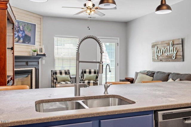 109 Covenant Rock Ln, Holly Springs, NC 27540 - kitchen with blue cabinets, dishwasher, a ceiling fan, and a glass covered fireplace
